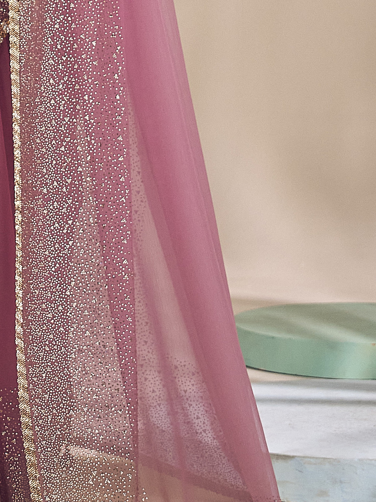 Pallu detail of mauve chiffon saree showing ornamented surface design and embellished border