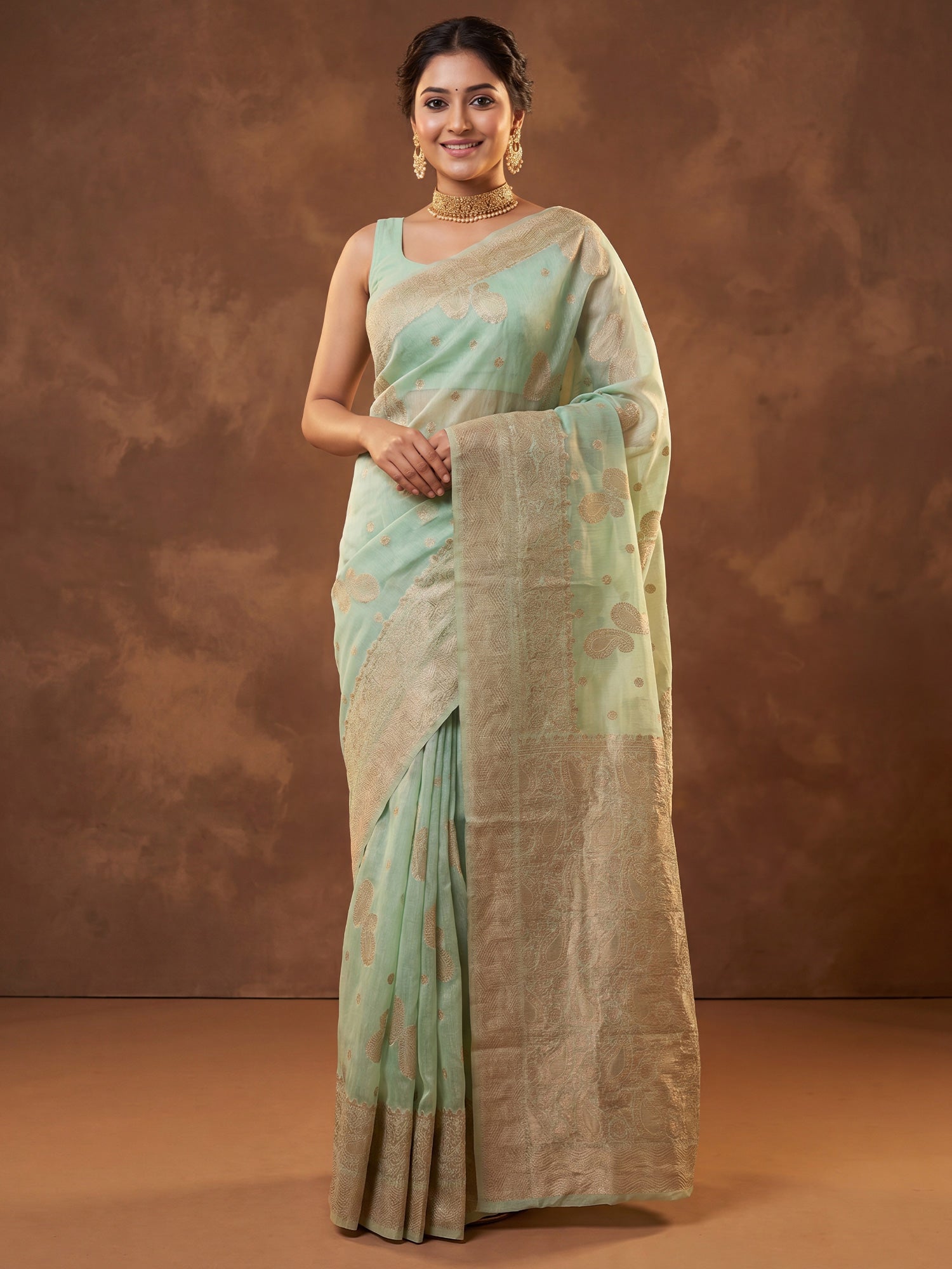 Woman wearing mint green silk blend saree with zari butta (metallic motif) work and mint green blouse