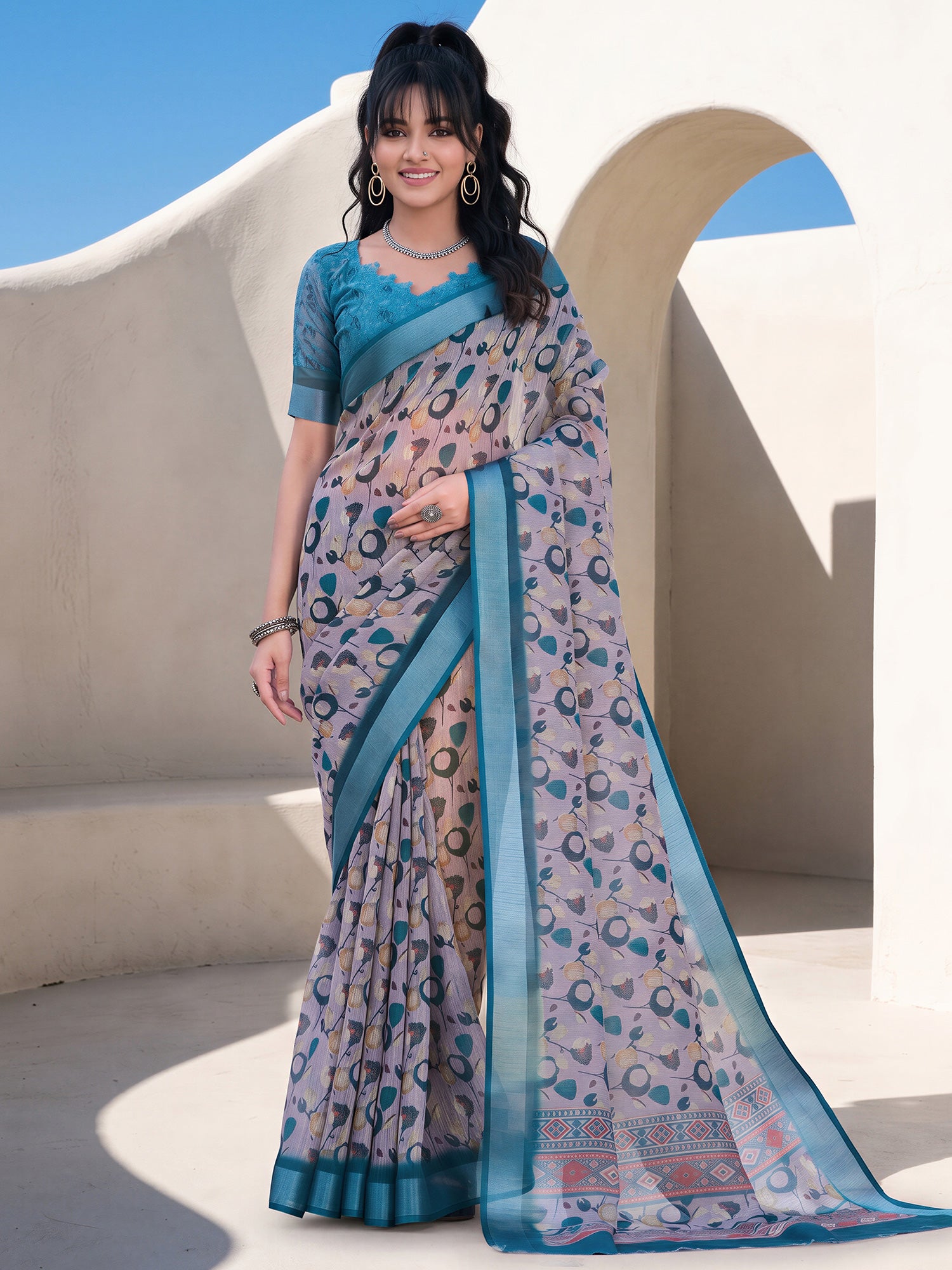 Woman wearing taupe cotton linen saree with traditional indian motif work and teal blue blouse