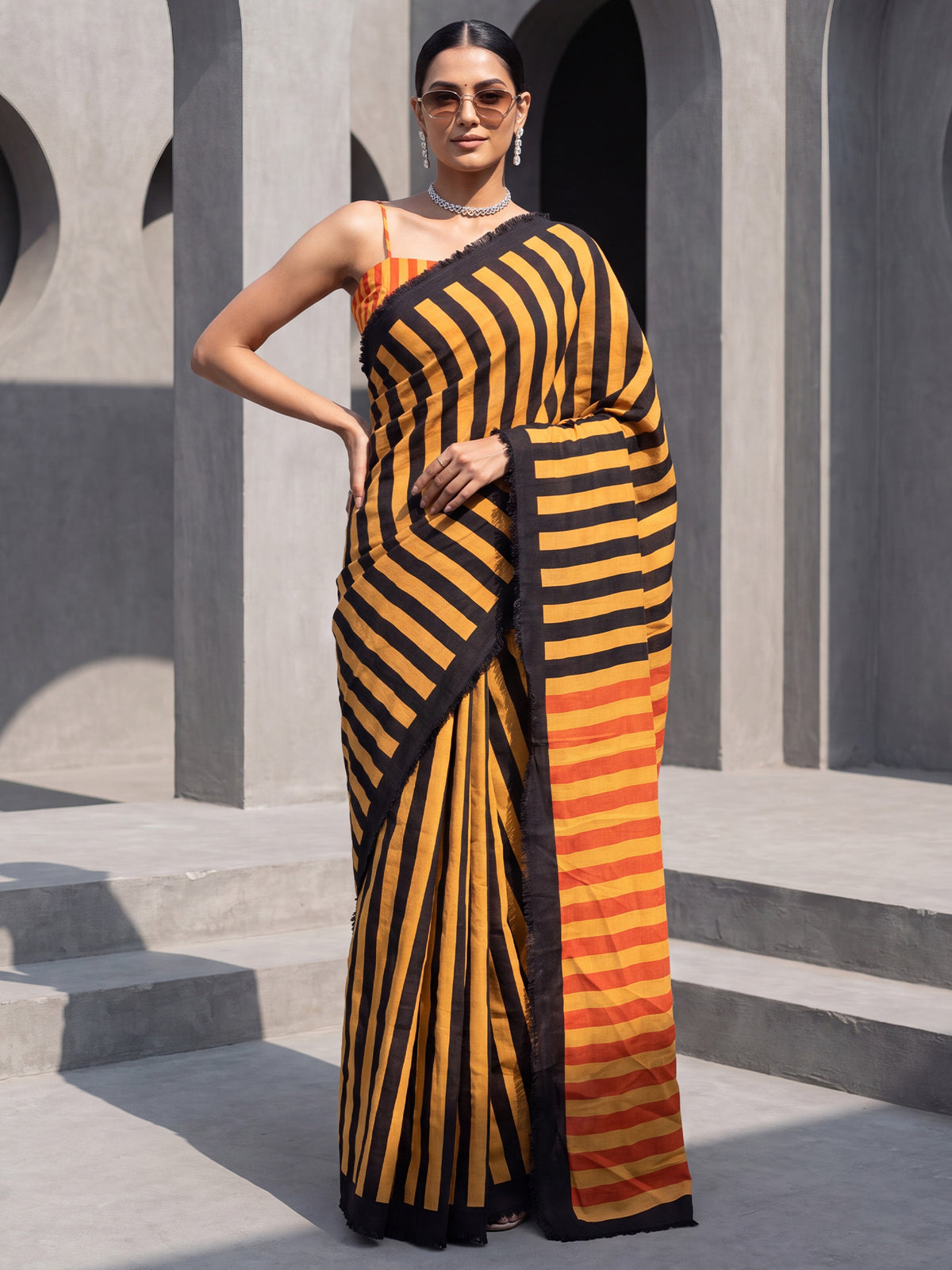 Woman wearing mustard cotton saree with striped pattern design and mustard blouse