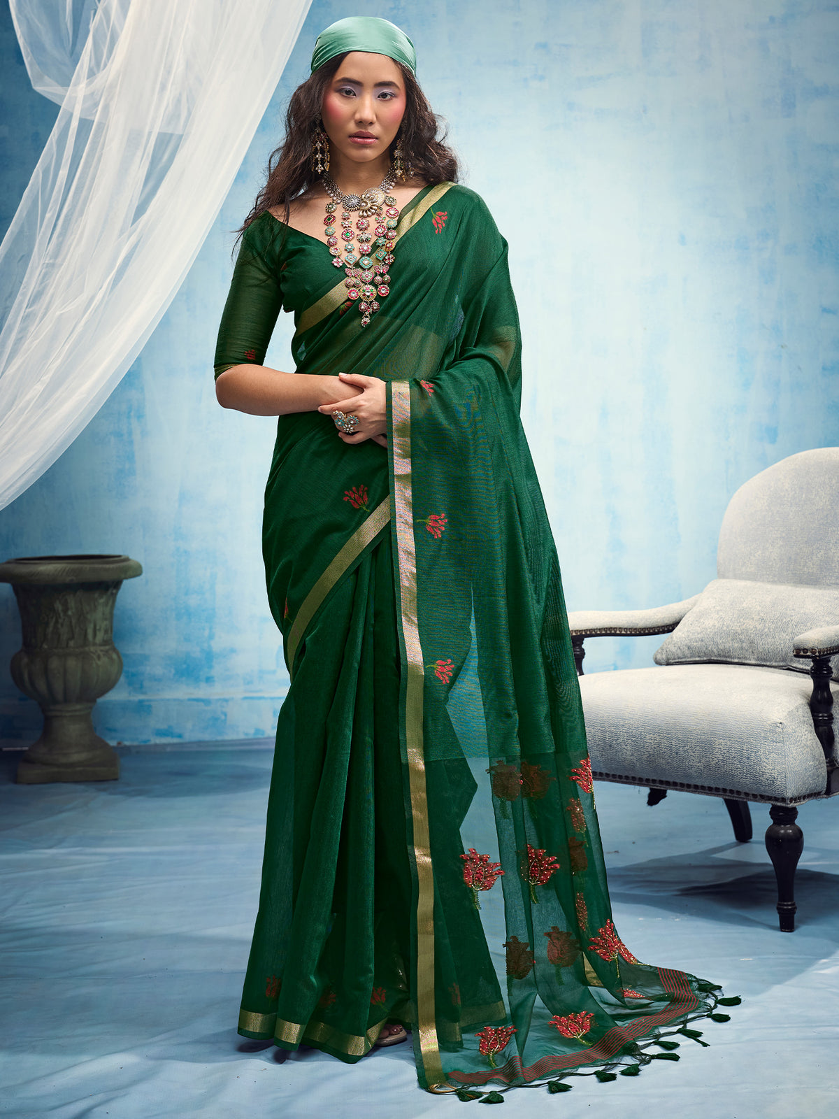Woman wearing green muga cotton saree with embroidered motif work and green blouse