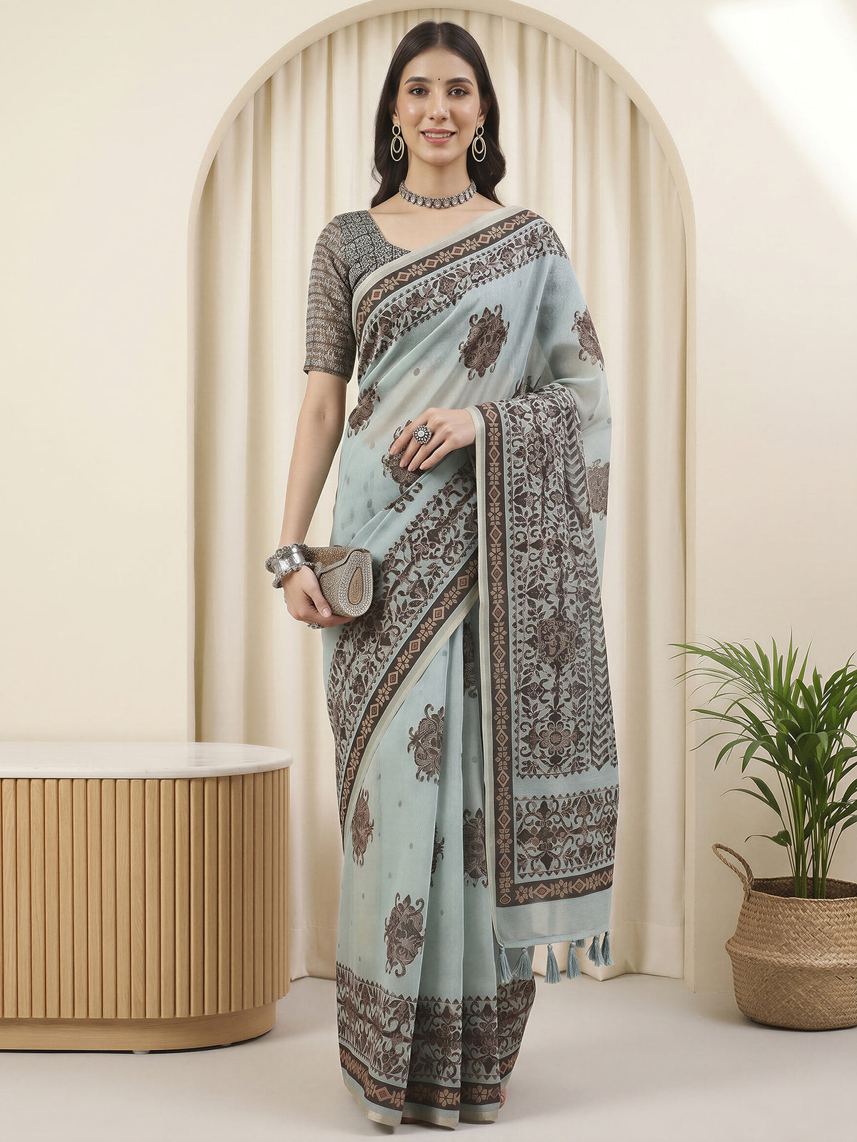 Woman wearing light blue cotton linen saree with hand block-printed motifs and light blue blouse
