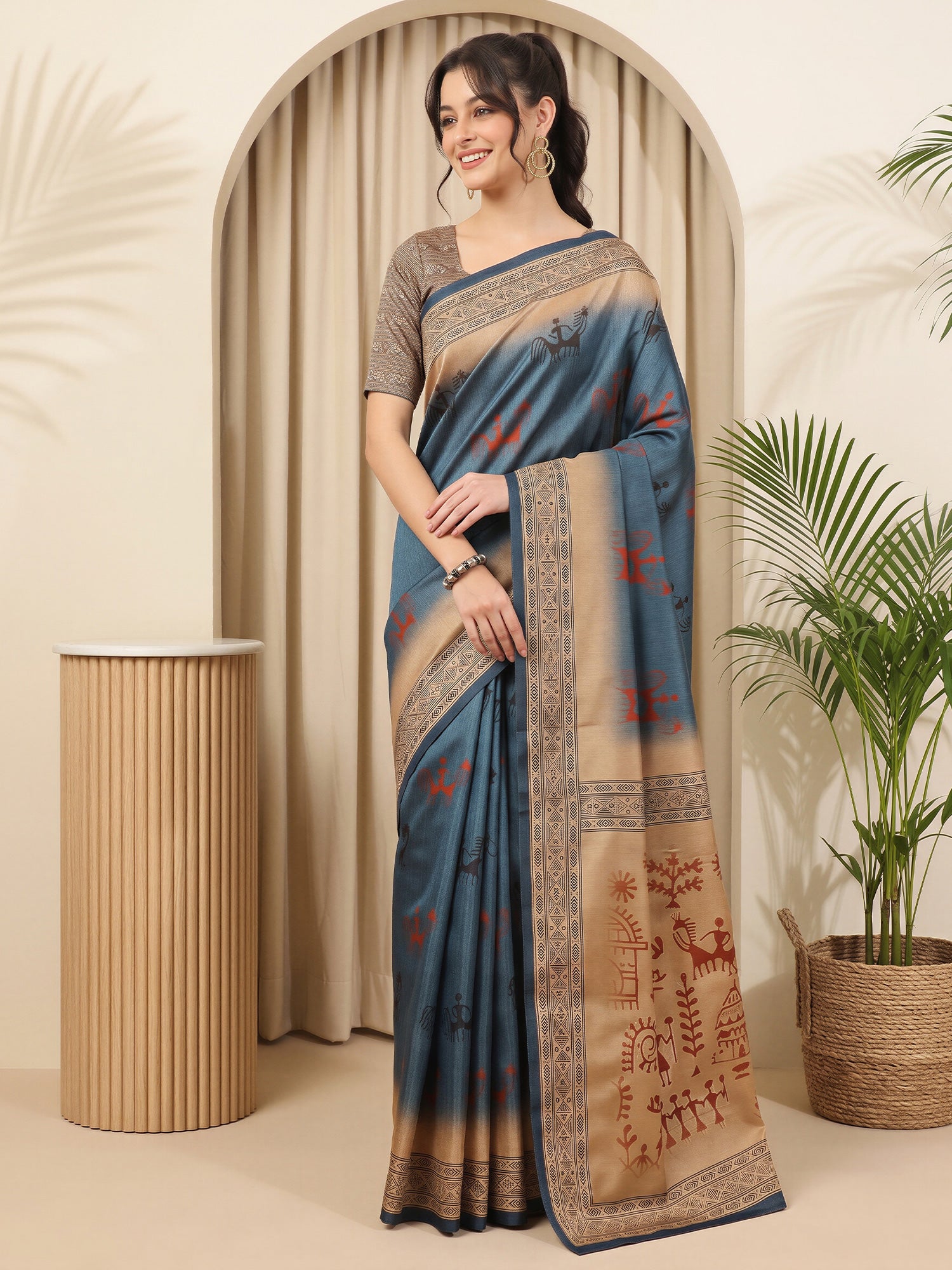 Woman wearing blue silk blend saree with tribal folk-art motifs and beige blouse