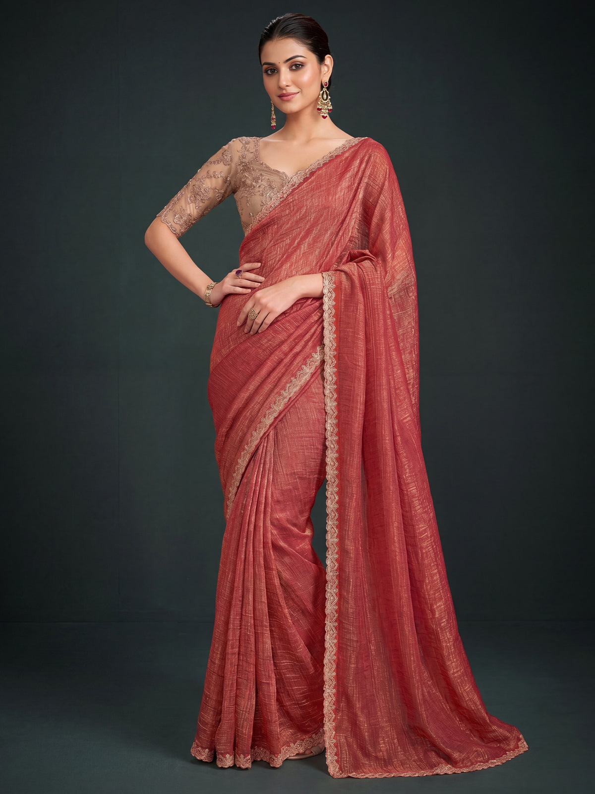Woman wearing rust georgette saree with ornamented surface design and beige blouse