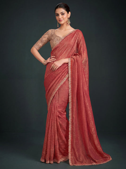 Woman wearing rust georgette saree with ornamented surface design and beige blouse