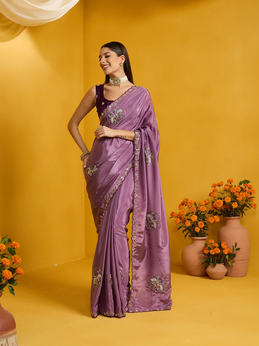 Woman wearing lavender silk blend saree with ornamented surface design and purple blouse