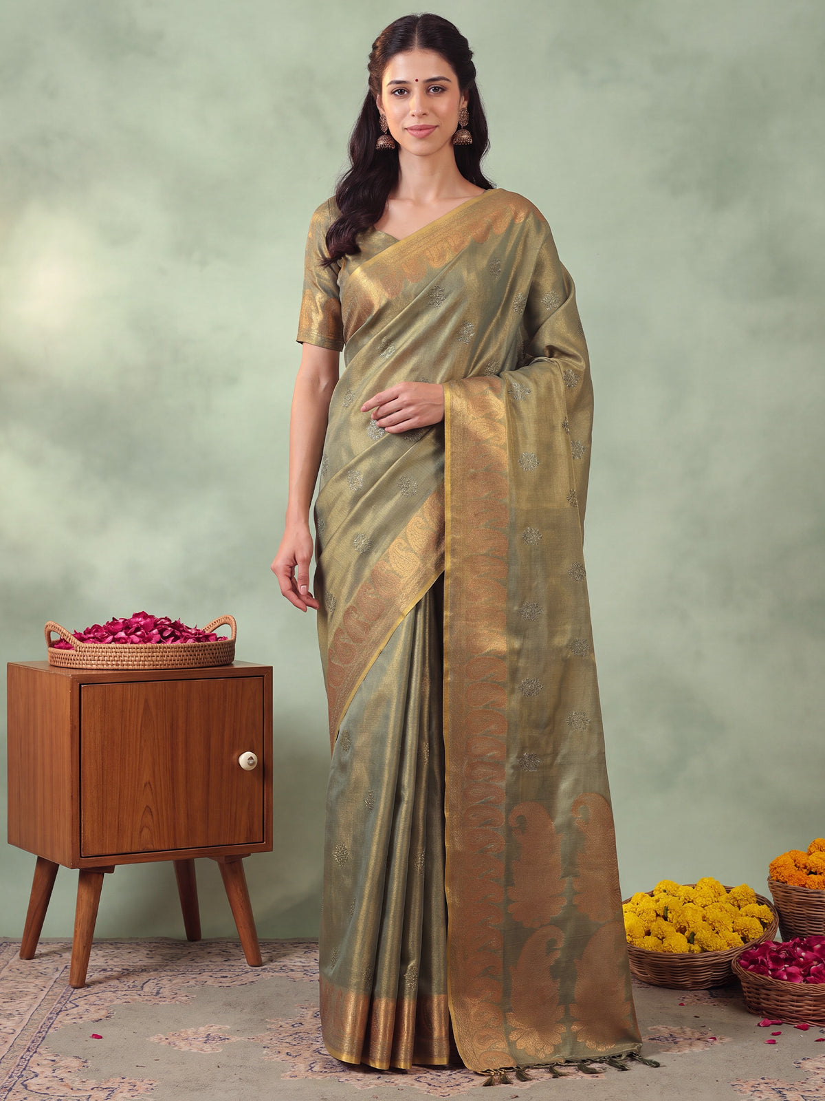 Woman wearing green linen saree with traditional indian motif work and green blouse