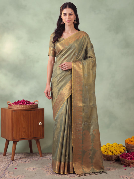 Woman wearing green linen saree with traditional indian motif work and green blouse