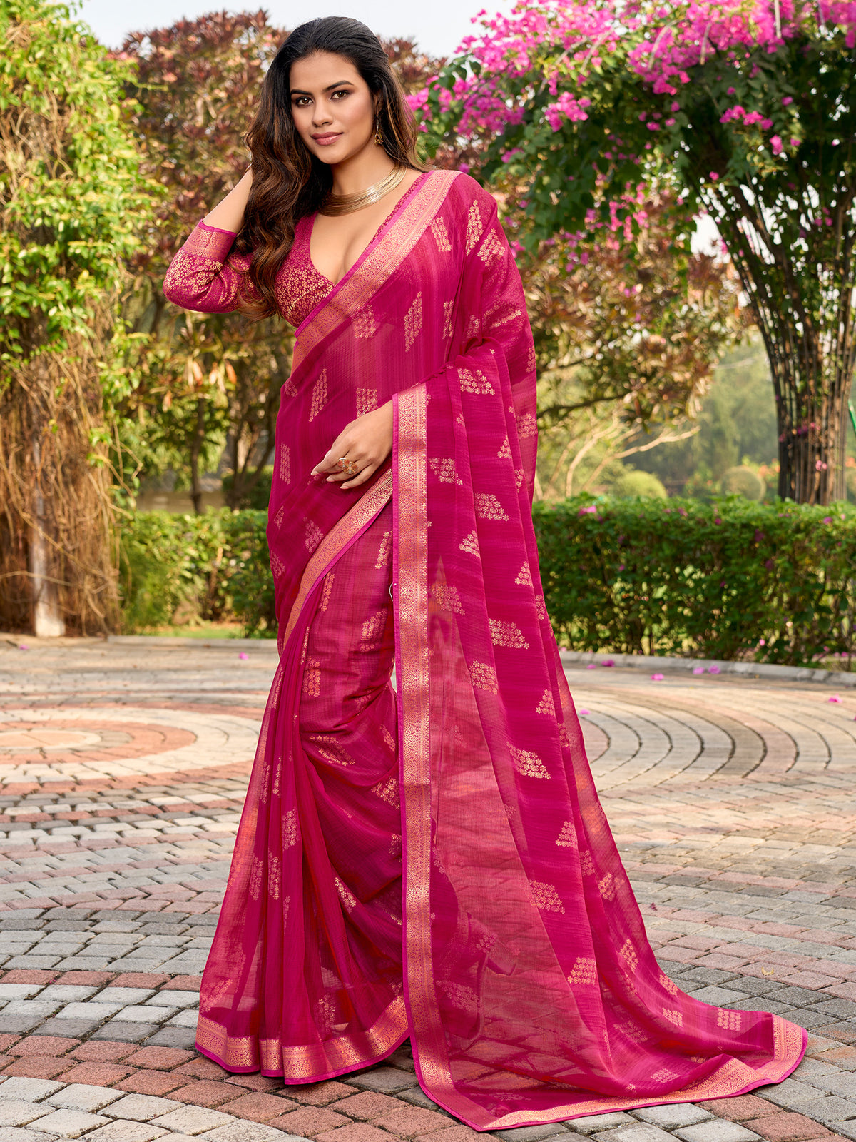 Woman wearing pink chiffon saree with metallic foil print work and pink blouse