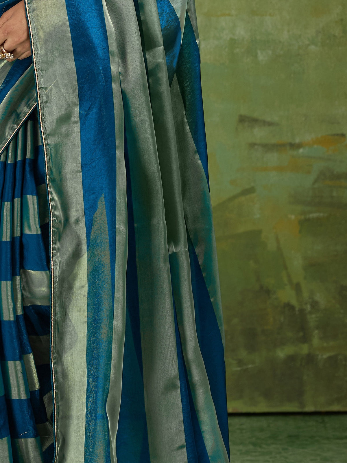 Pallu detail of teal blue satin silk saree showing colour-blocked design and zari border