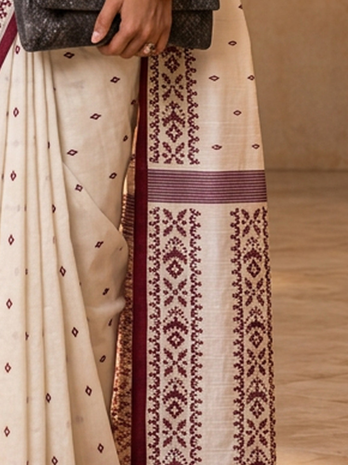 Pallu detail of off white tussar silk saree showing traditional indian motif work and printed border