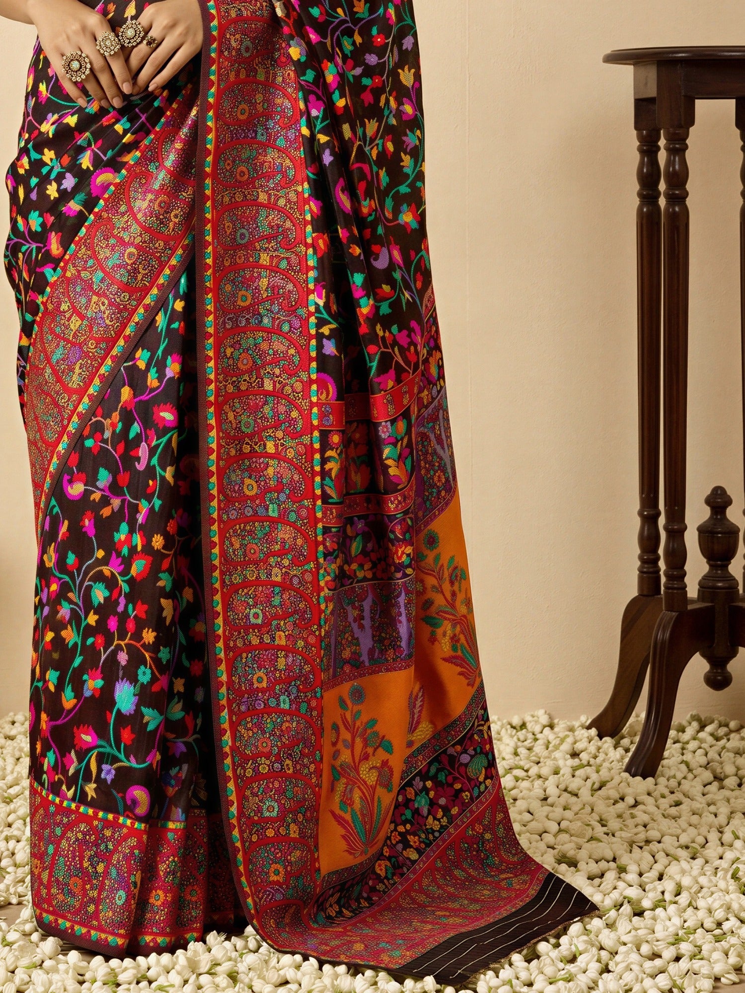 Pallu detail of black cotton silk saree showing all-over floral design and woven design border