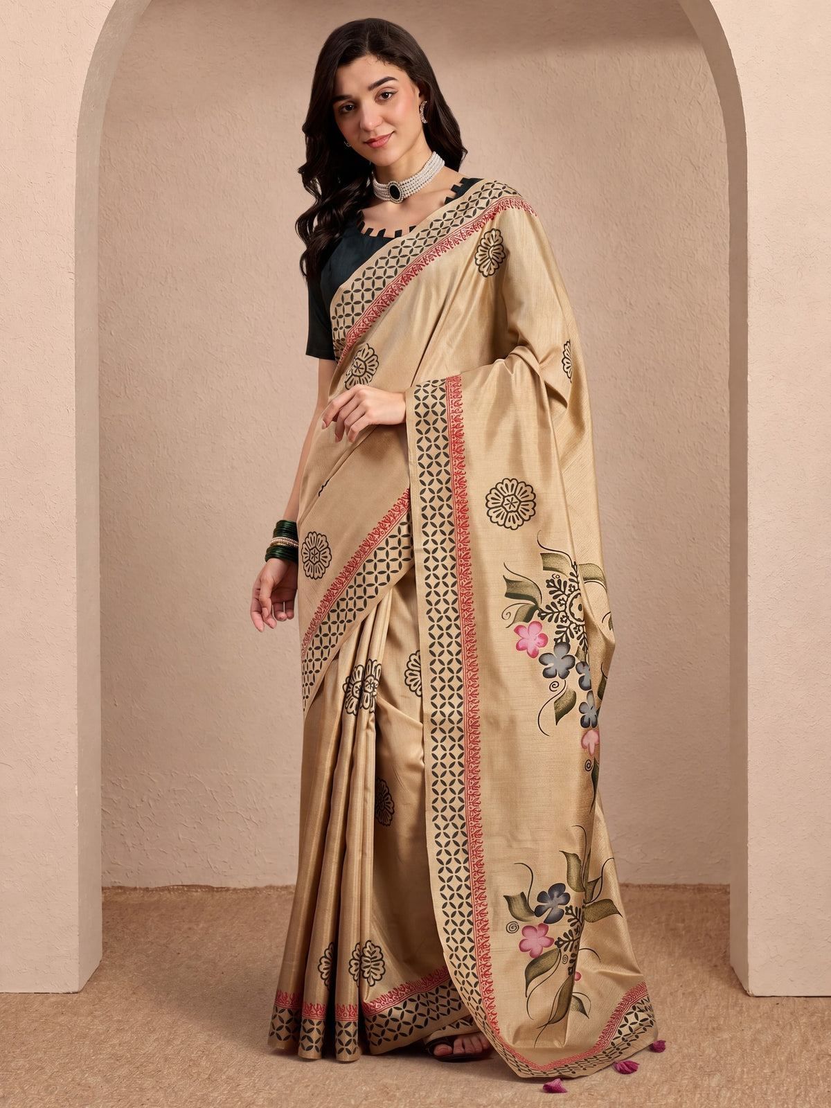 Woman wearing beige silk blend saree with hand-painted motif work and black blouse