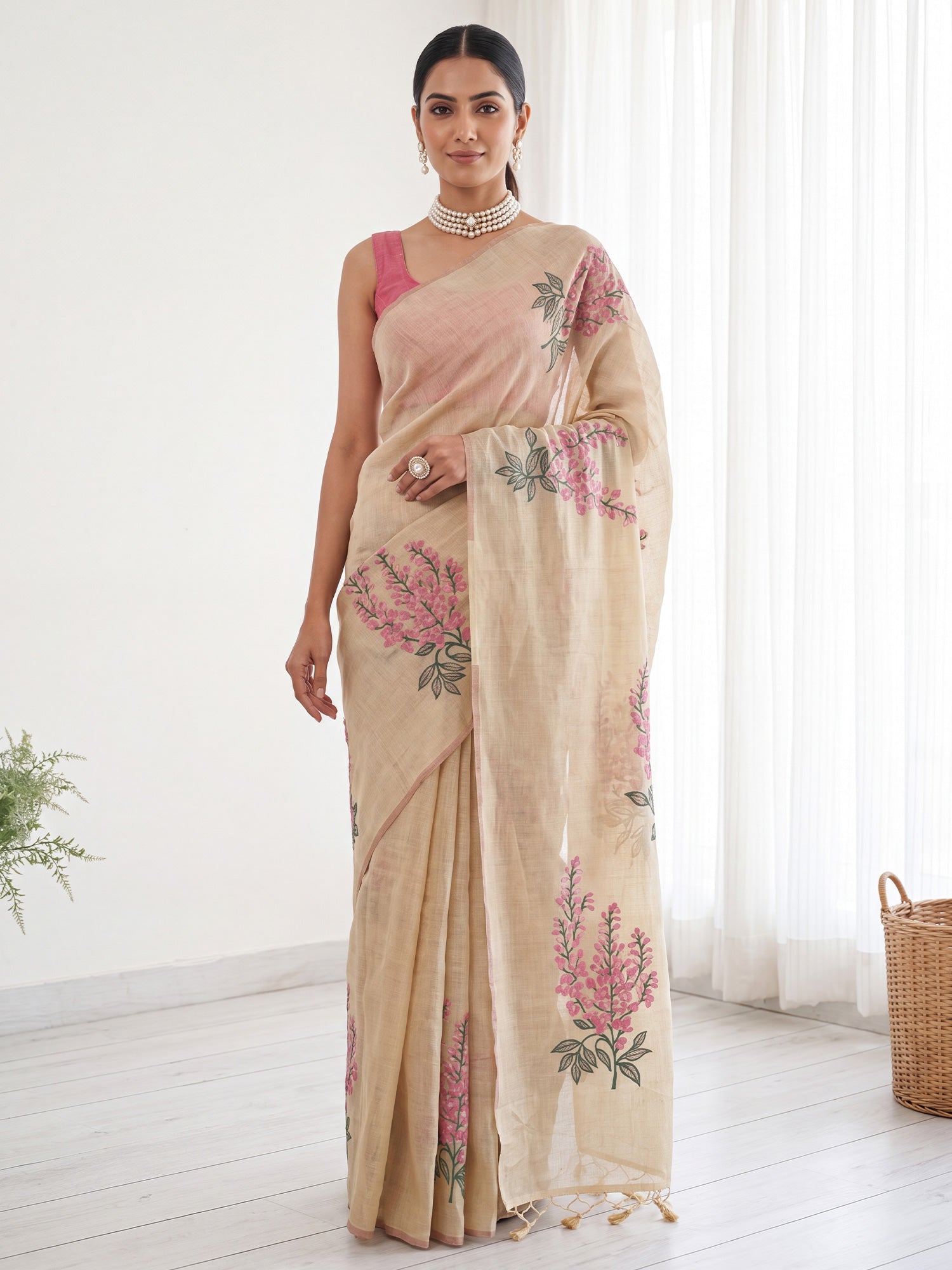 Woman wearing cream cotton linen saree with all-over floral design and peach blouse