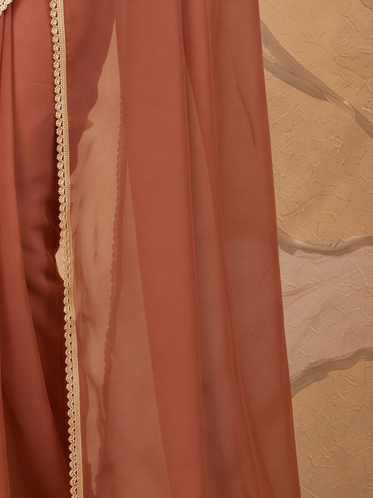 Pallu detail of rust satin silk saree showing clean solid-tone finish and embellished border