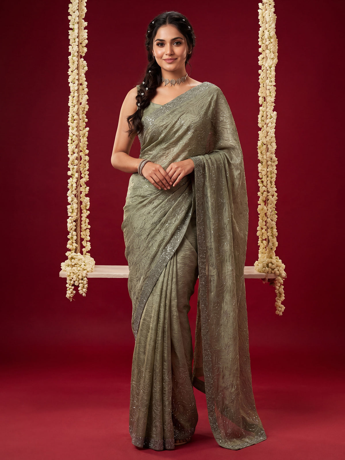 Woman wearing olive tissue saree with ornamented surface design and olive blouse