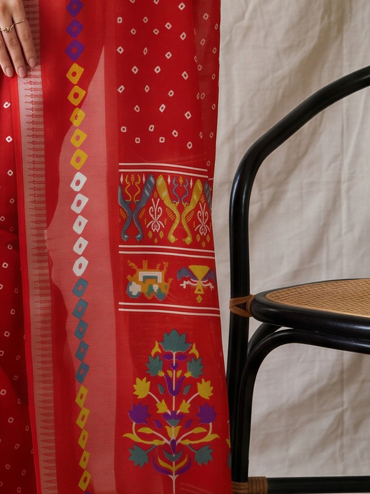 Pallu detail of red georgette saree showing bandhani tie-dye dot work and zari border