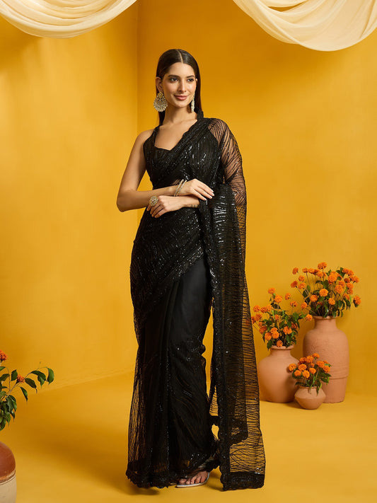Woman wearing black net saree with ornamented surface design and black blouse