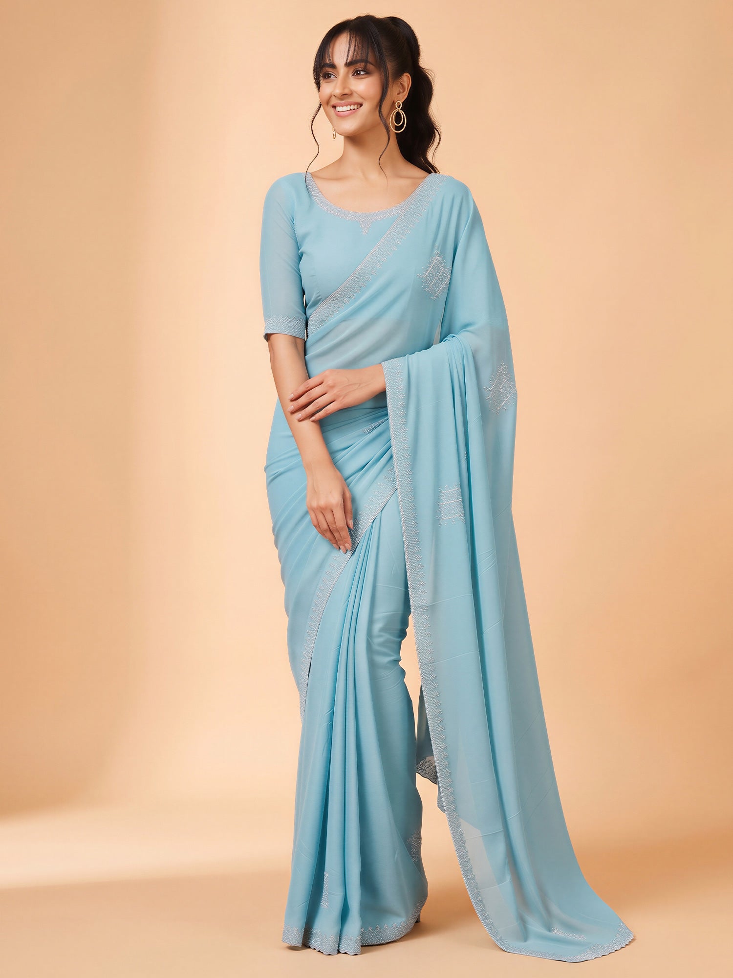 Woman wearing light blue georgette saree with ornamented surface design and light blue blouse