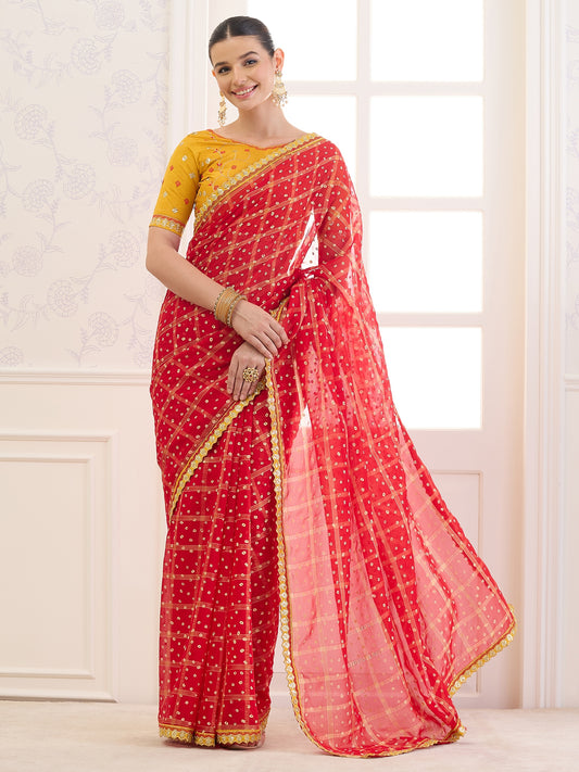Woman wearing red viscose saree with bandhani tie-dye dot work and yellow blouse