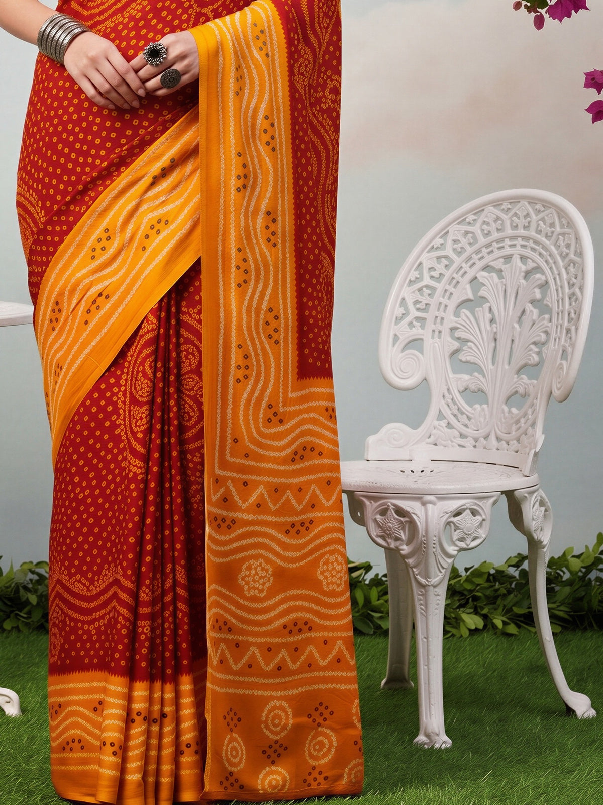 Pallu detail of red satin silk saree showing bandhani tie-dye dot work and printed border