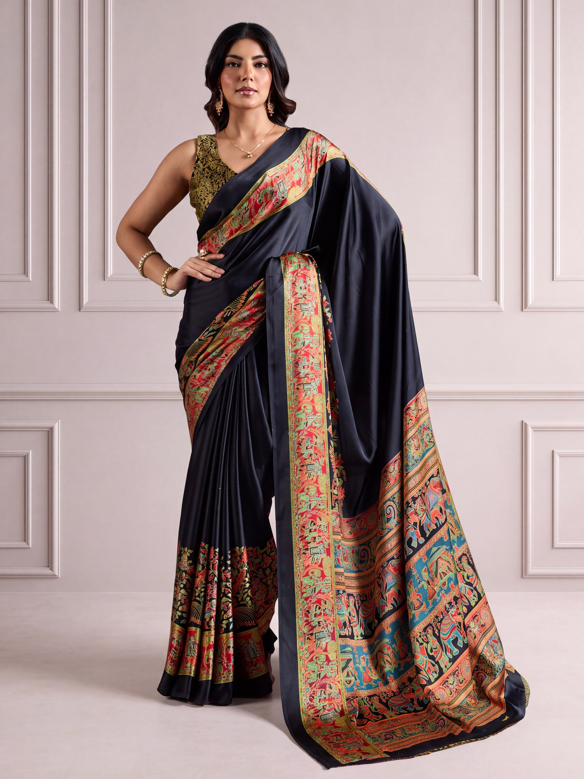 Woman wearing black satin saree with madhubani folk-art motifs and black blouse