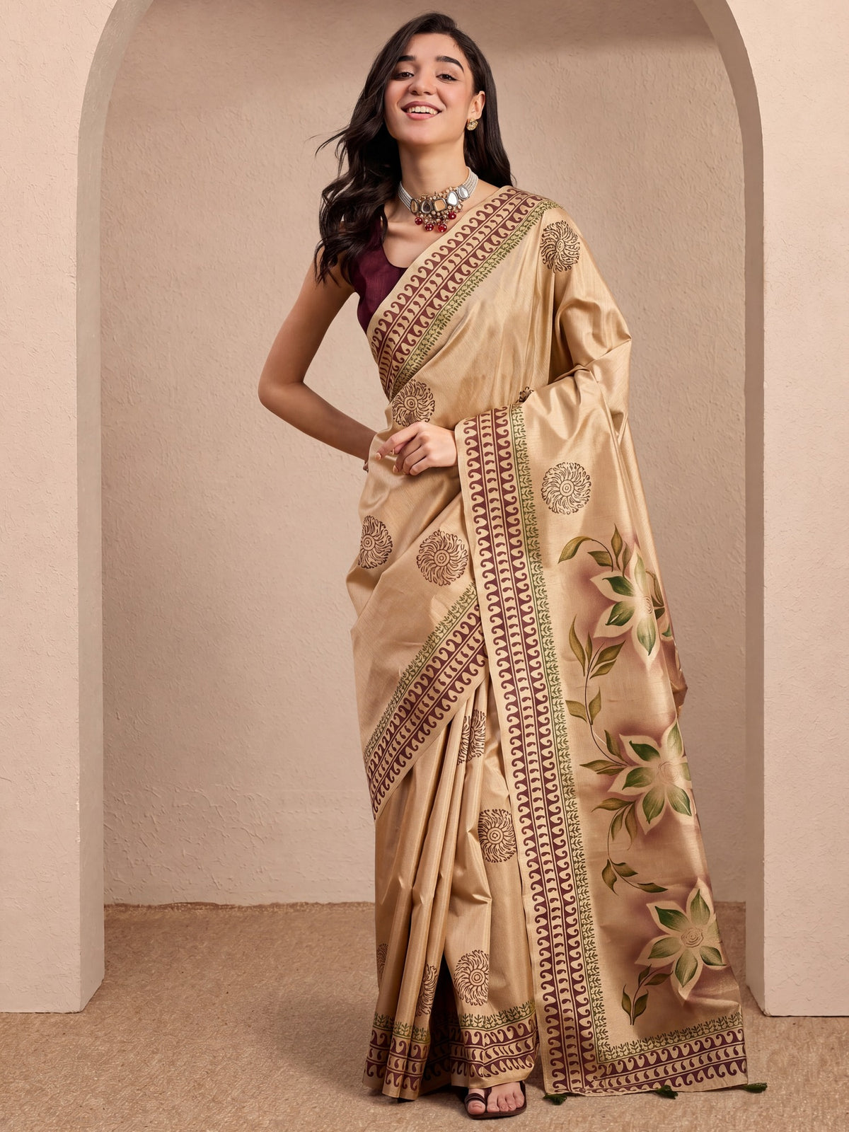Woman wearing beige silk blend saree with hand-painted motif work and burgundy blouse