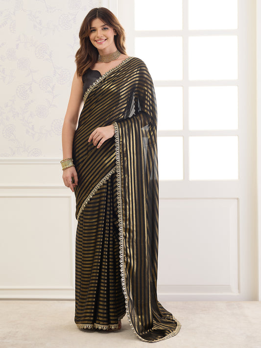 Woman wearing black satin saree with striped pattern design and black blouse