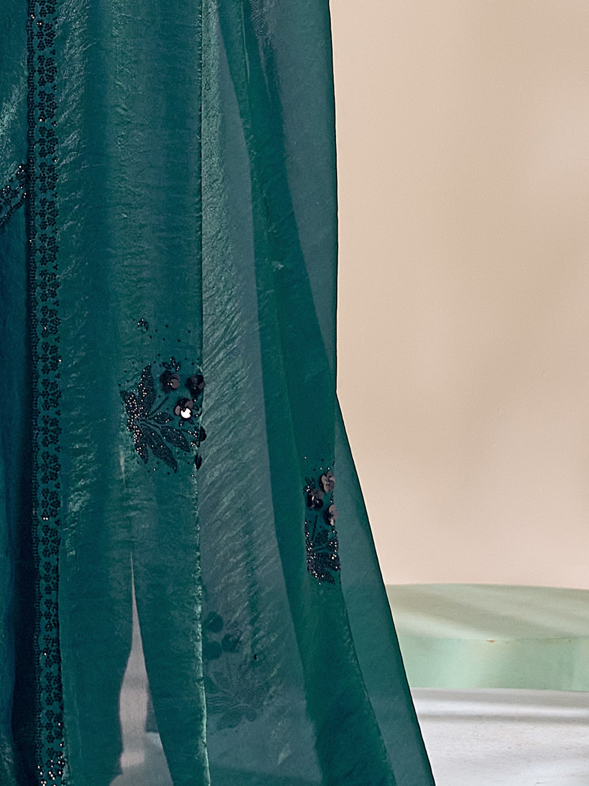 Pallu detail of teal satin silk saree showing ornamented surface design and scallop border