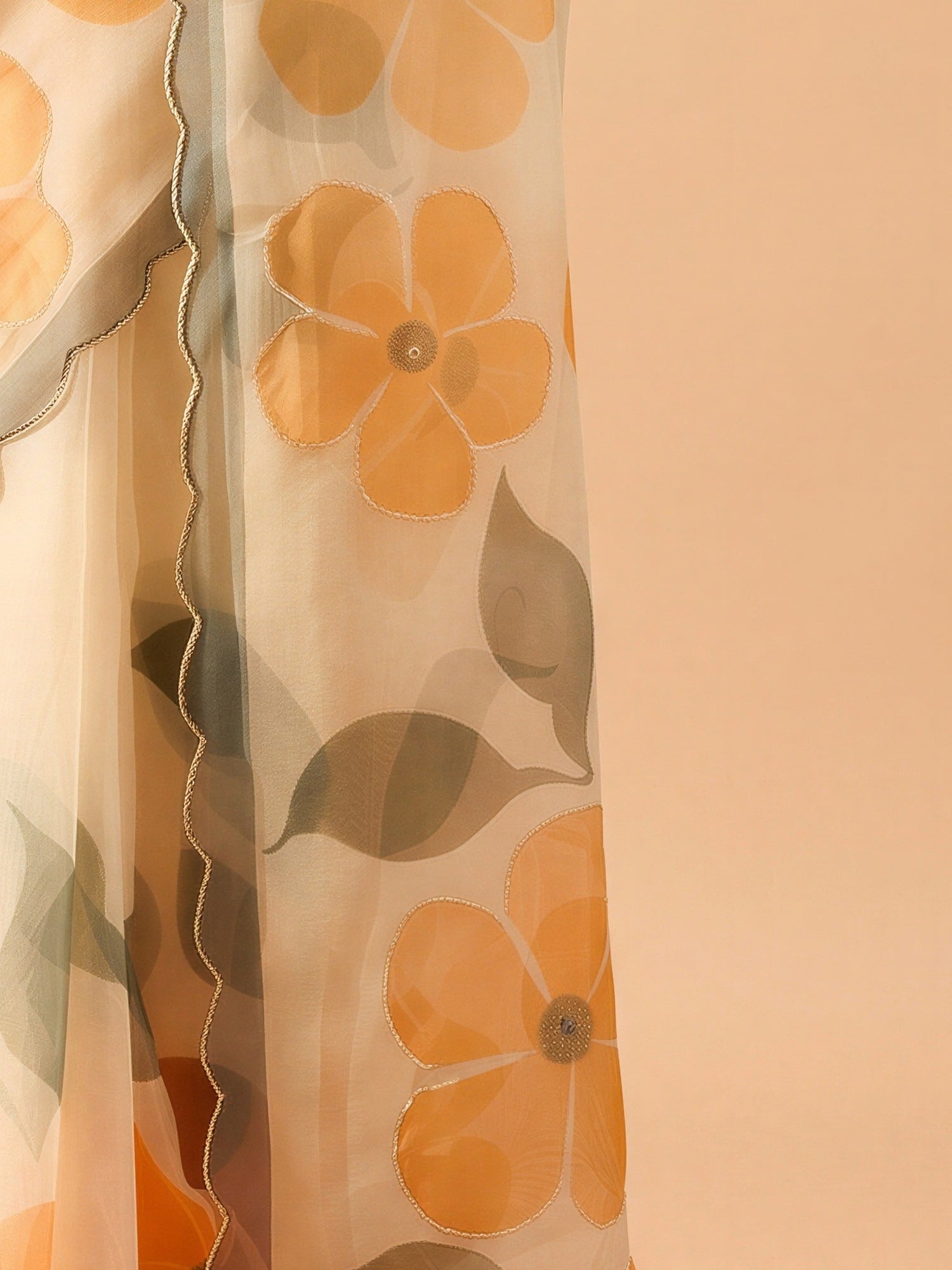 Pallu detail of cream organza saree showing all-over floral design and embellished border
