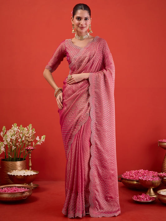 Woman wearing pink satin saree with ornamented surface design and pink blouse