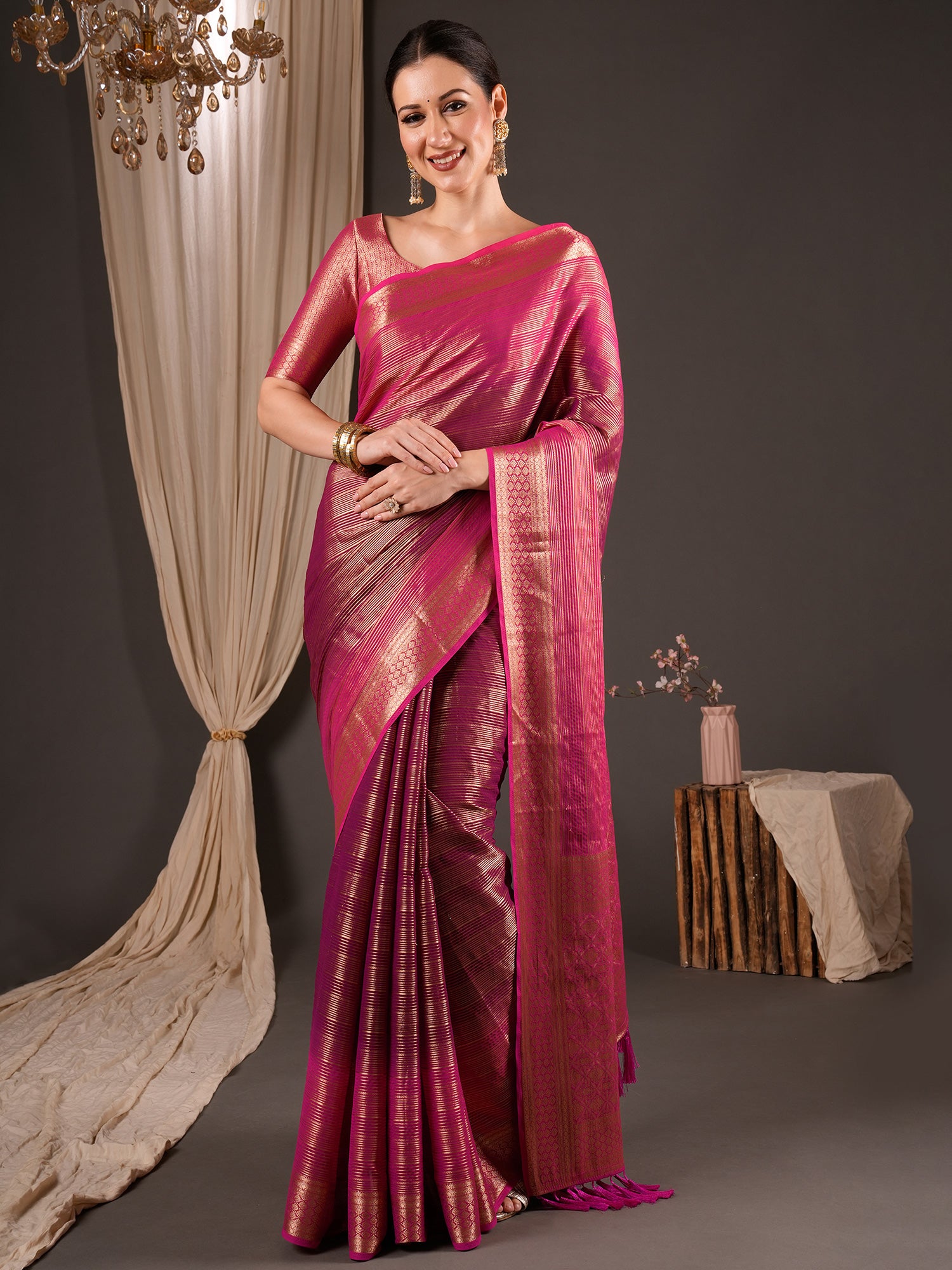 Woman wearing wine viscose silk saree with striped pattern design and pink blouse