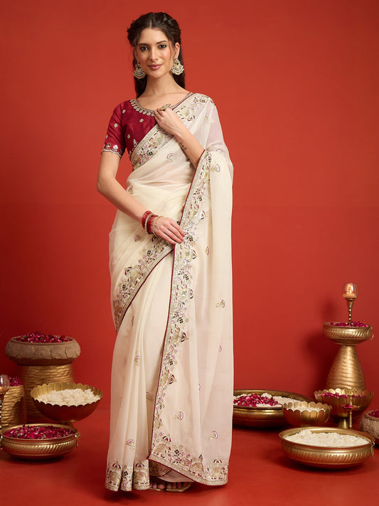 Woman wearing off white georgette saree with ornamented surface design and maroon blouse