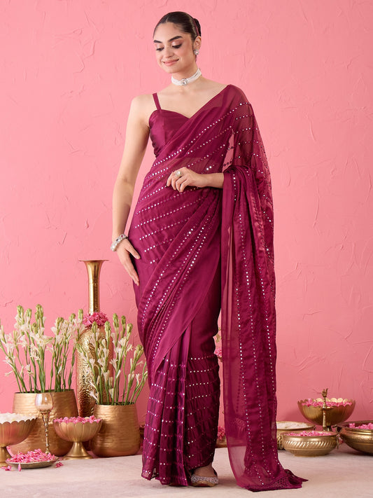 Woman wearing magenta georgette ready to wear saree with ornamented surface design and magenta blouse