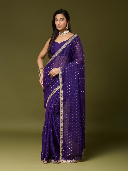 Woman wearing purple georgette saree with ornamented surface design and purple blouse