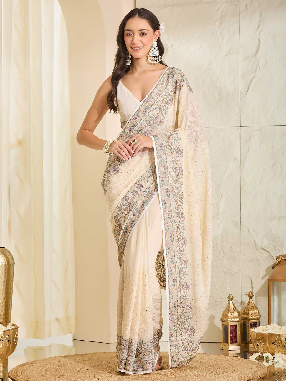 Woman wearing off white georgette saree with ornamented surface design and off white blouse