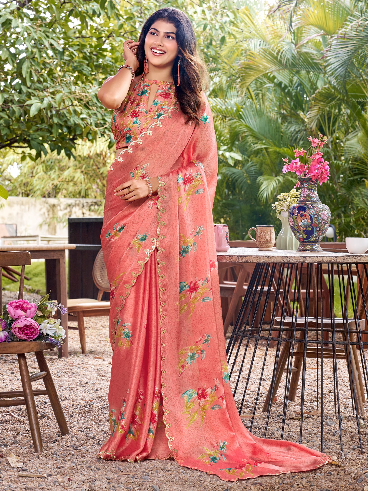Woman wearing peach chiffon saree with metallic foil print work and multicolored blouse