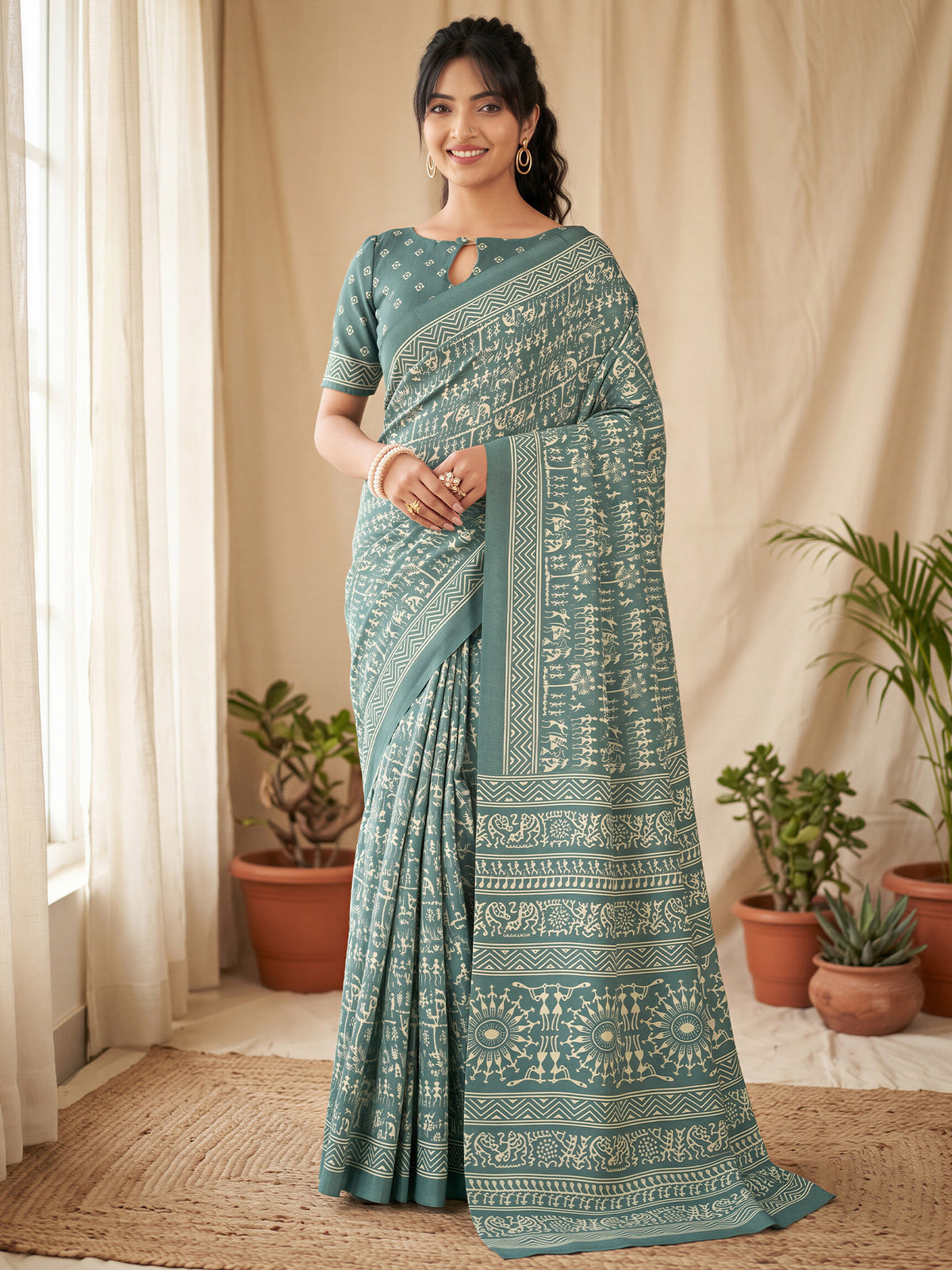 Woman wearing seagreen dola silk saree with warli folk-art figures and sea green blouse