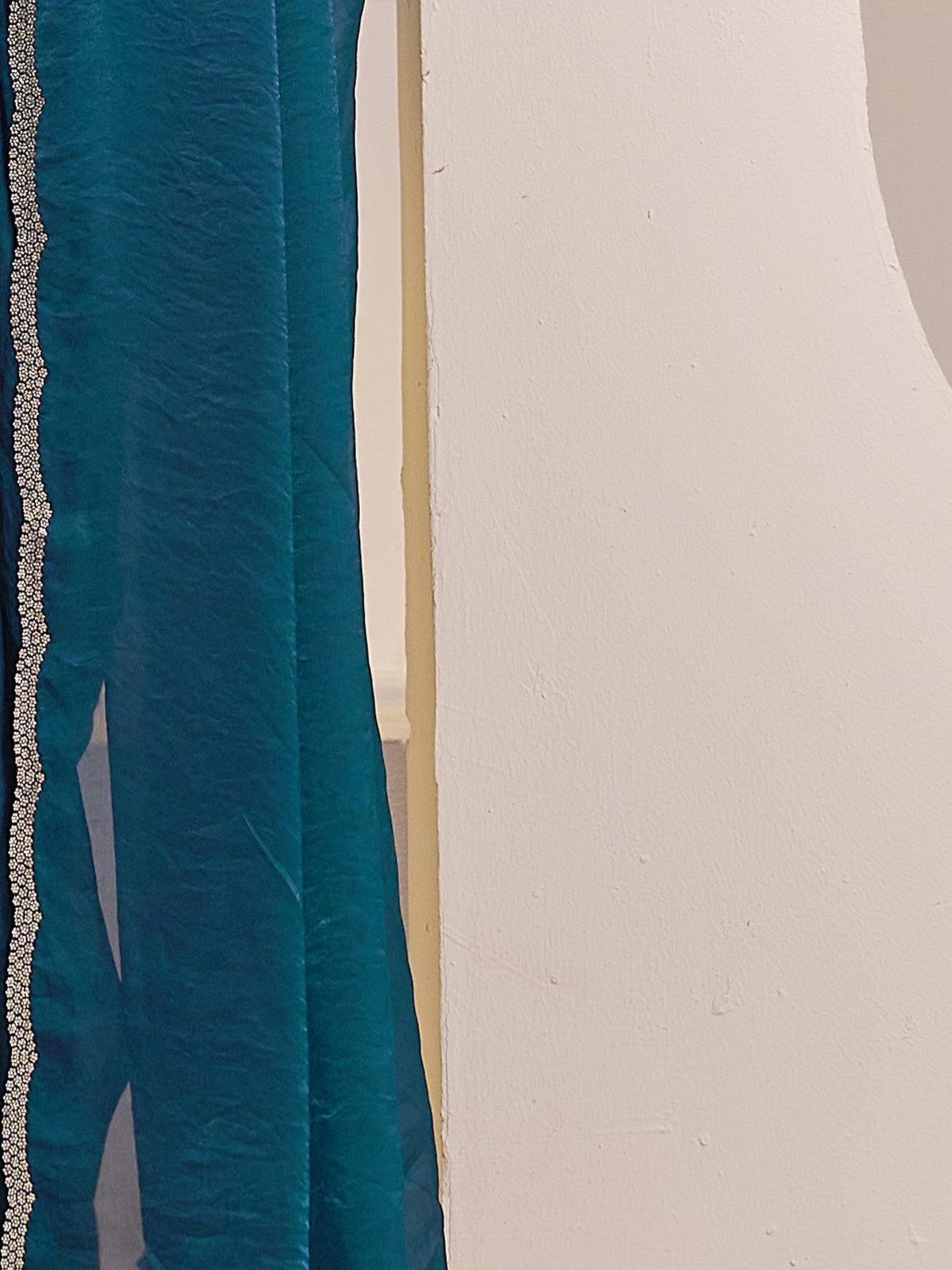 Pallu detail of teal blue satin silk saree showing clean solid-tone finish and embellished border