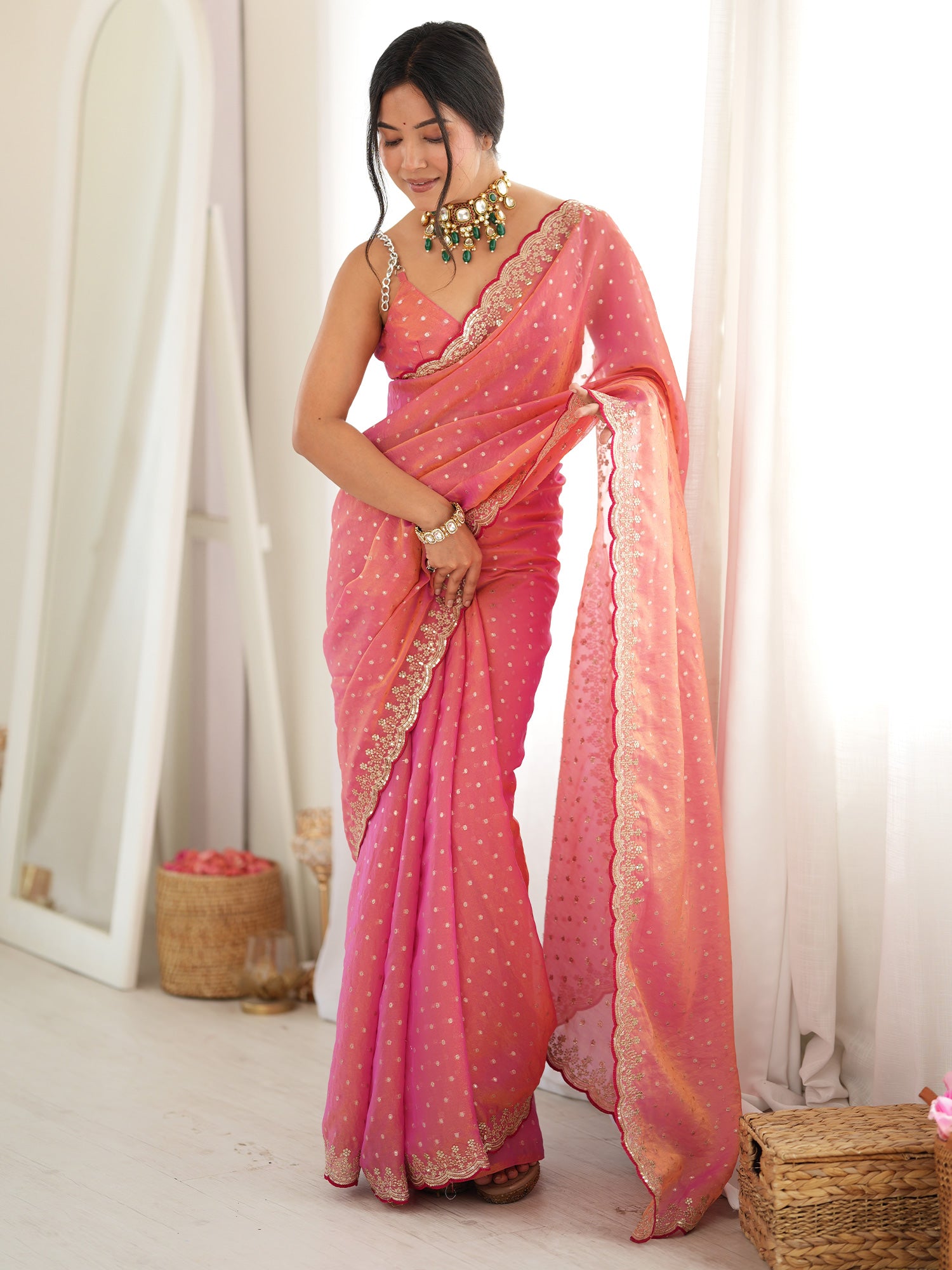 Woman wearing pink silk blend saree with ornamented surface design and pink blouse