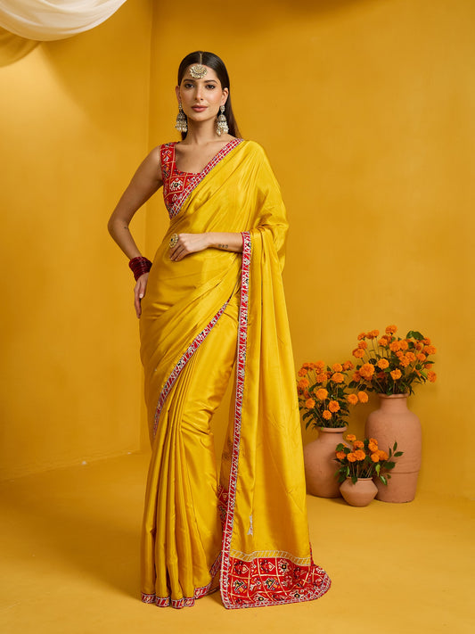 Woman wearing yellow silk blend saree with ornamented surface design and red blouse