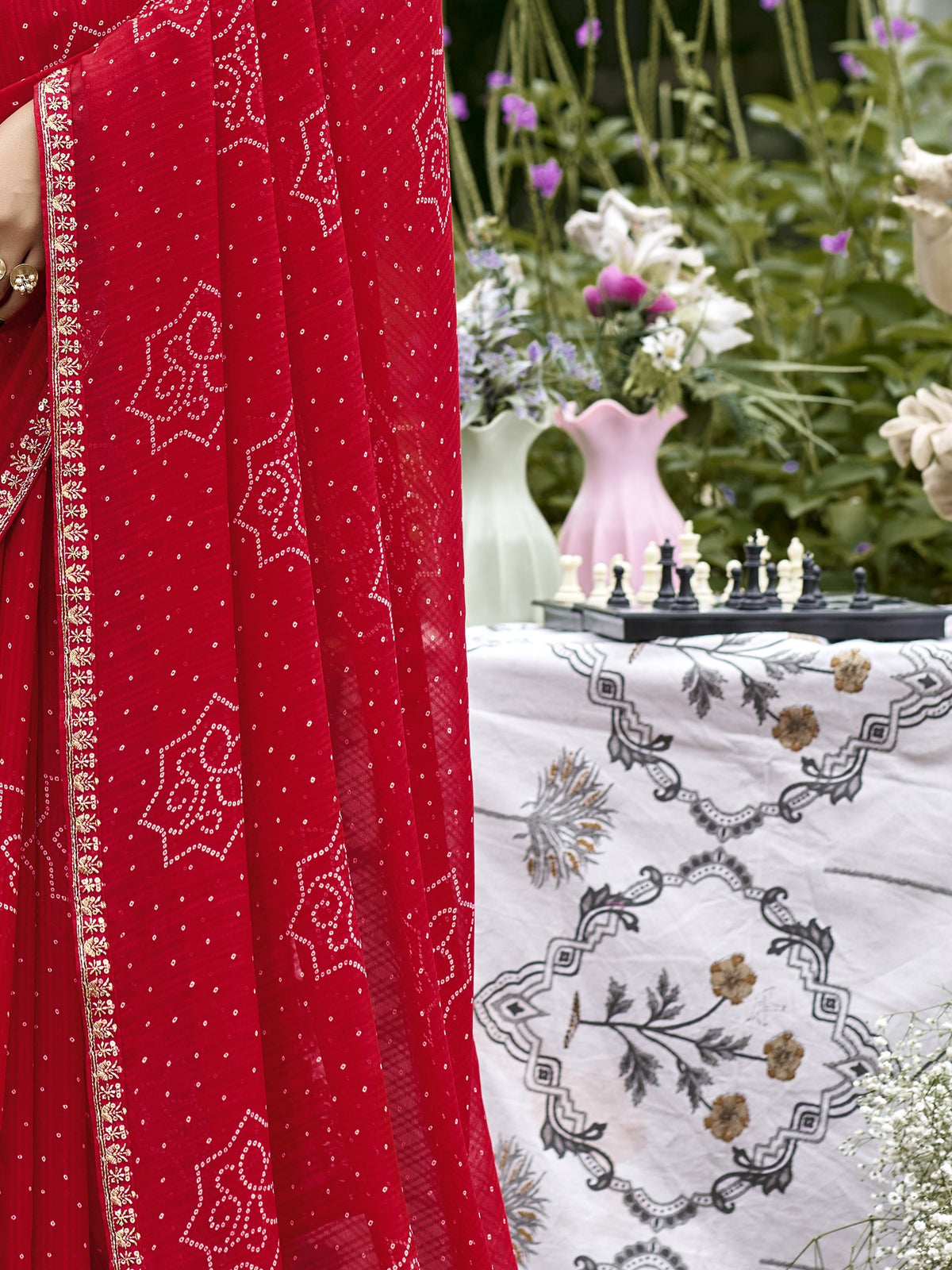 Pallu detail of red georgette saree showing bandhani tie-dye dot work and zari border