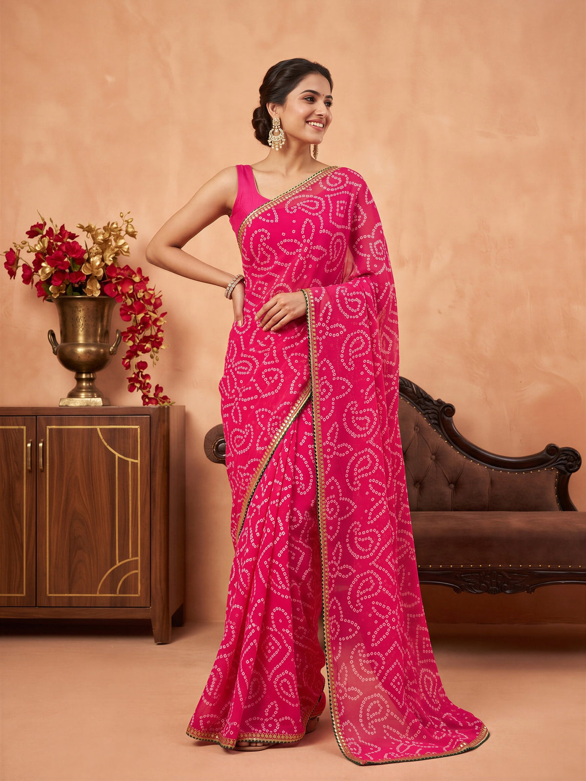 Woman wearing pink georgette saree with bandhani tie-dye dot work and pink blouse