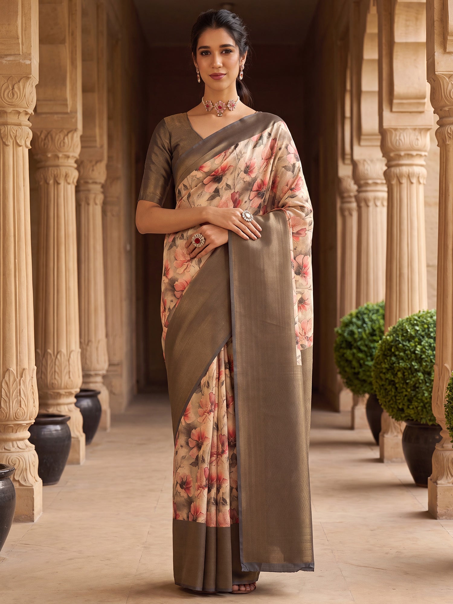 Woman wearing beige silk blend saree with all-over floral design and charcoal grey blouse