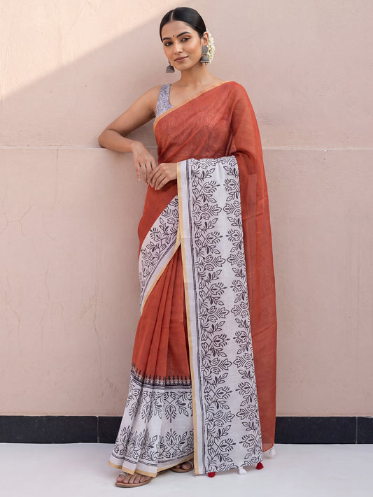 Woman wearing rust cotton linen saree with traditional indian print motifs and off white blouse