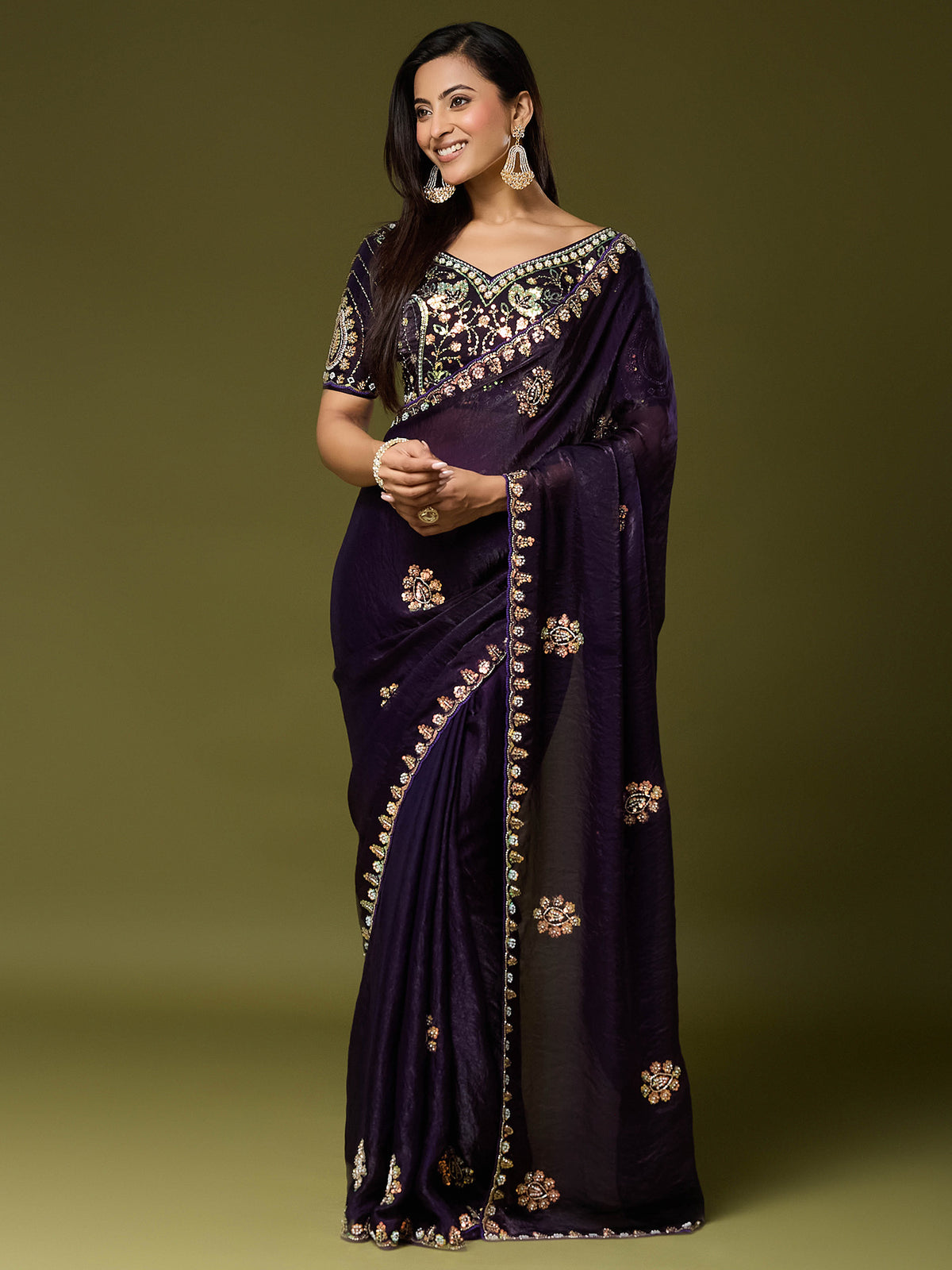 Woman wearing purple satin silk saree with ornamented surface design and purple blouse