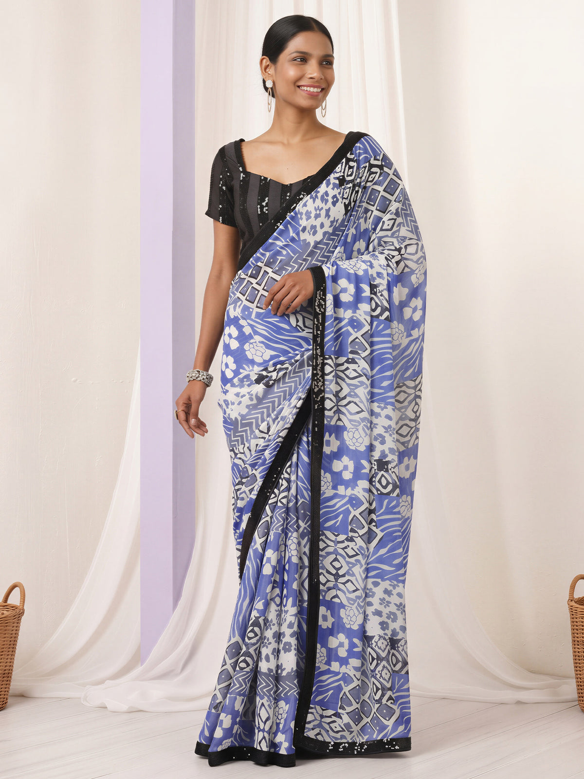 Woman wearing light blue pure georgette saree with abstract contemporary design and black blouse