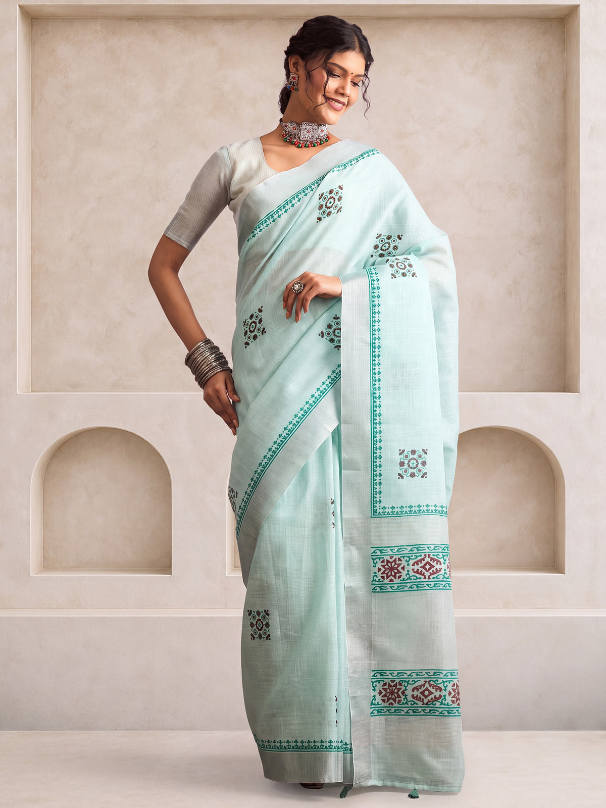 Woman wearing mint green linen saree with bagh block-print motif work and mint green blouse