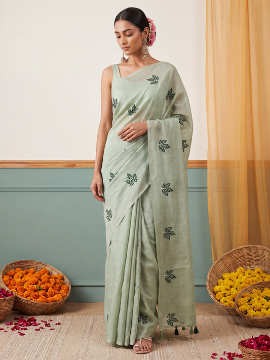 Woman wearing mint green kota doria cotton saree with embroidered motif work and mint green blouse