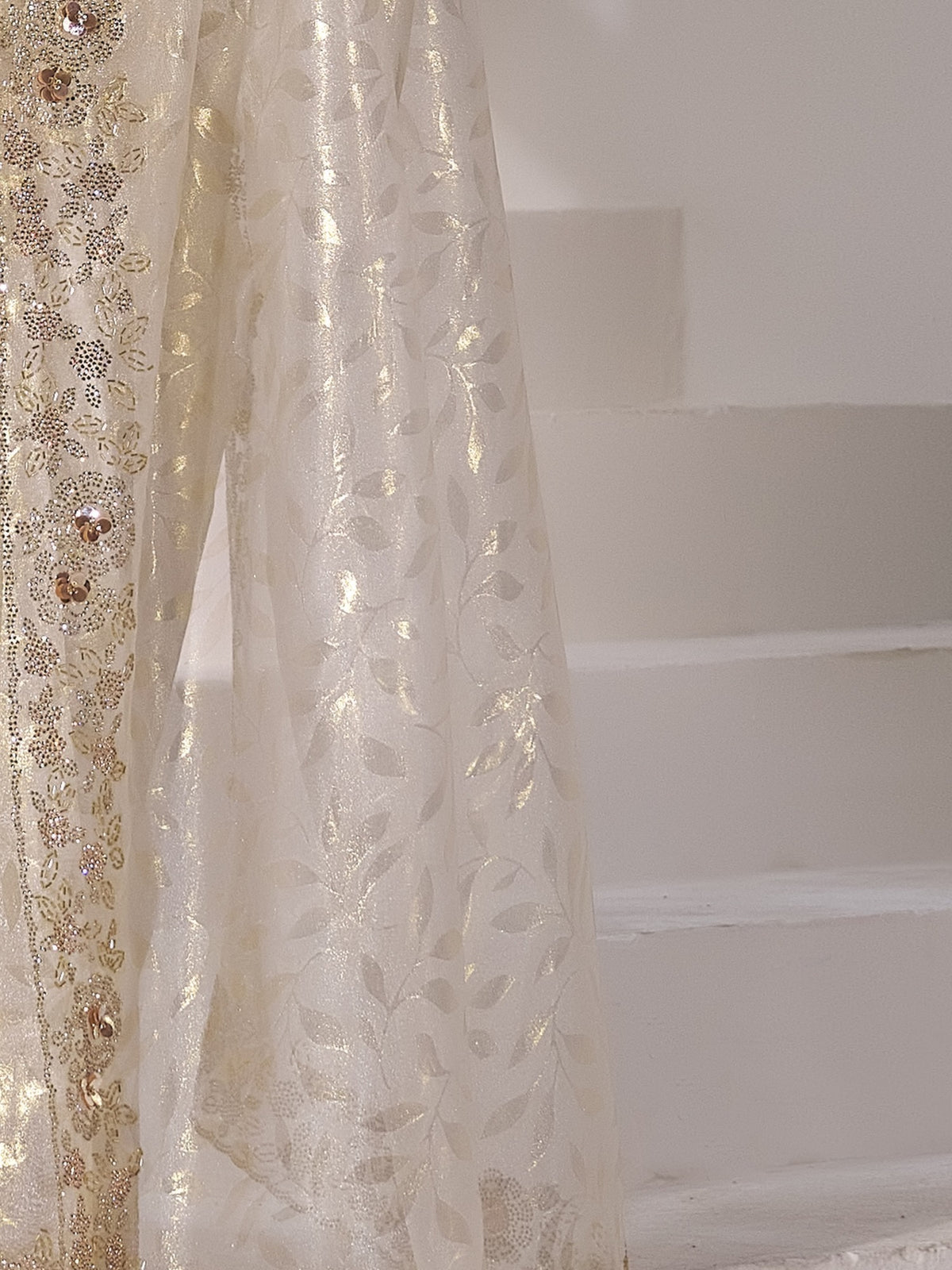 Pallu detail of off white organza saree showing applique design and scallop border